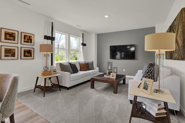 living room with wood finished floors, baseboards, and recessed lighting