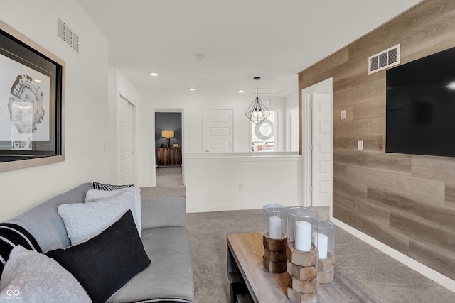 living area featuring carpet floors, recessed lighting, and wood walls