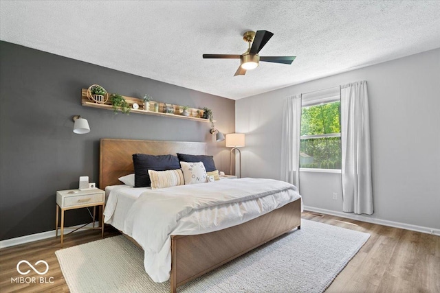 10444 Collingswood Ln, Fishers, IN 46037 - bedroom with a textured ceiling, wood finished floors, baseboards, and a ceiling fan
