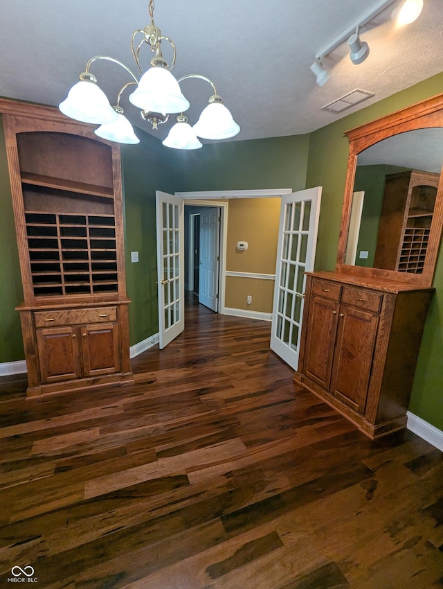 9640 Bramblewood Way, Carmel, IN 46032 - unfurnished dining area with french doors, dark wood finished floors, baseboards, a chandelier, and track lighting