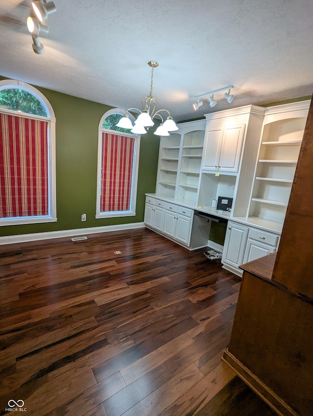 9640 Bramblewood Way, Carmel, IN 46032 - unfurnished dining area featuring track lighting, dark wood finished floors, baseboards, a chandelier, and a textured ceiling