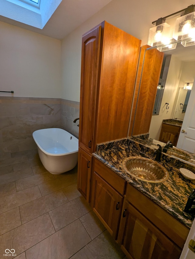 9640 Bramblewood Way, Carmel, IN 46032 - bathroom featuring tile patterned flooring, a freestanding tub, a skylight, vanity, and tile walls