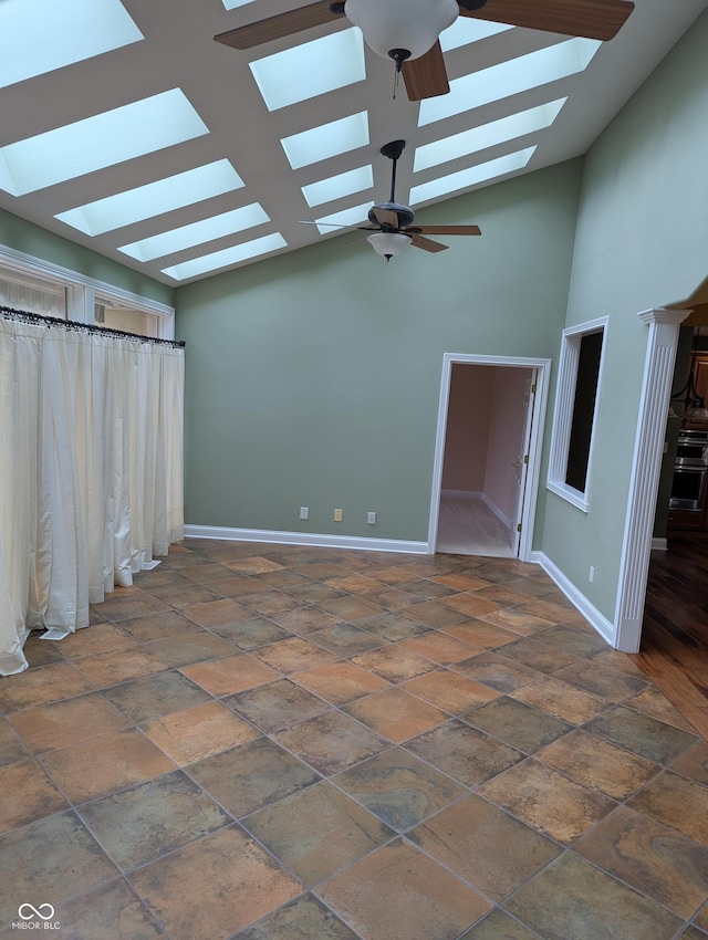 9640 Bramblewood Way, Carmel, IN 46032 - unfurnished living room featuring a skylight, vaulted ceiling, ceiling fan, baseboards, and stone finish floors