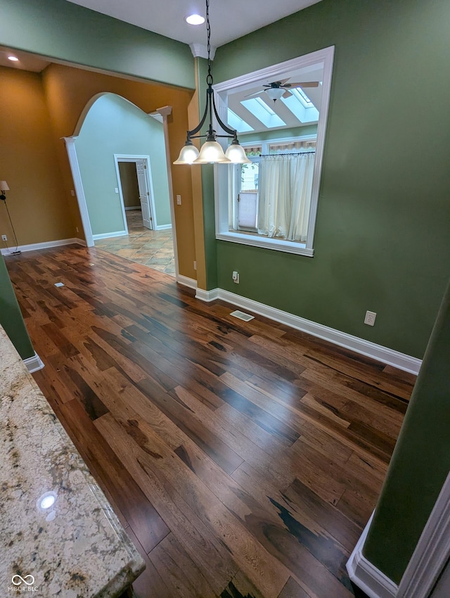 9640 Bramblewood Way, Carmel, IN 46032 - unfurnished dining area with a skylight, wood finished floors, arched walkways, baseboards, and recessed lighting