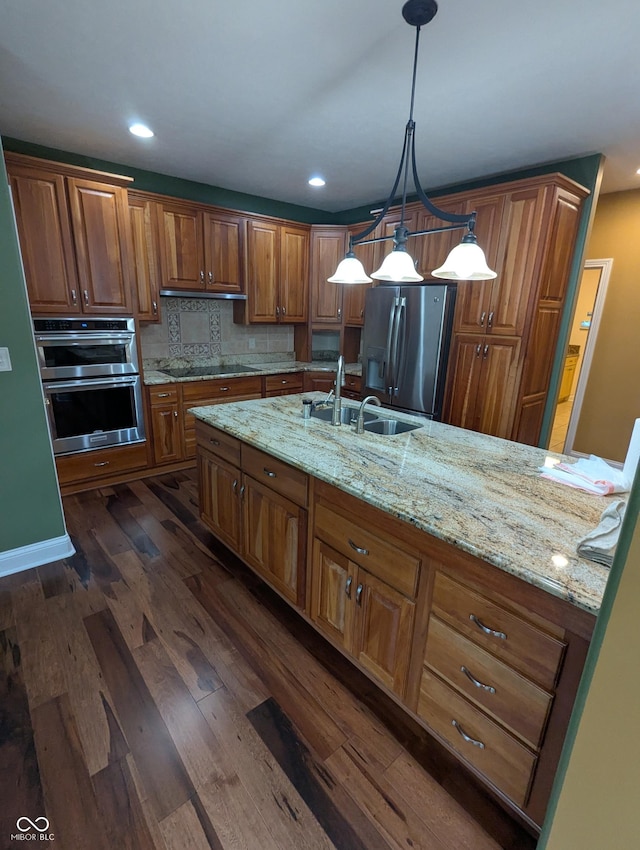 9640 Bramblewood Way, Carmel, IN 46032 - kitchen featuring appliances with stainless steel finishes, a sink, brown cabinets, dark wood finished floors, and light stone counters