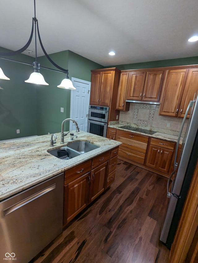 9640 Bramblewood Way, Carmel, IN 46032 - kitchen featuring appliances with stainless steel finishes, a sink, dark wood-style floors, pendant lighting, and light stone countertops