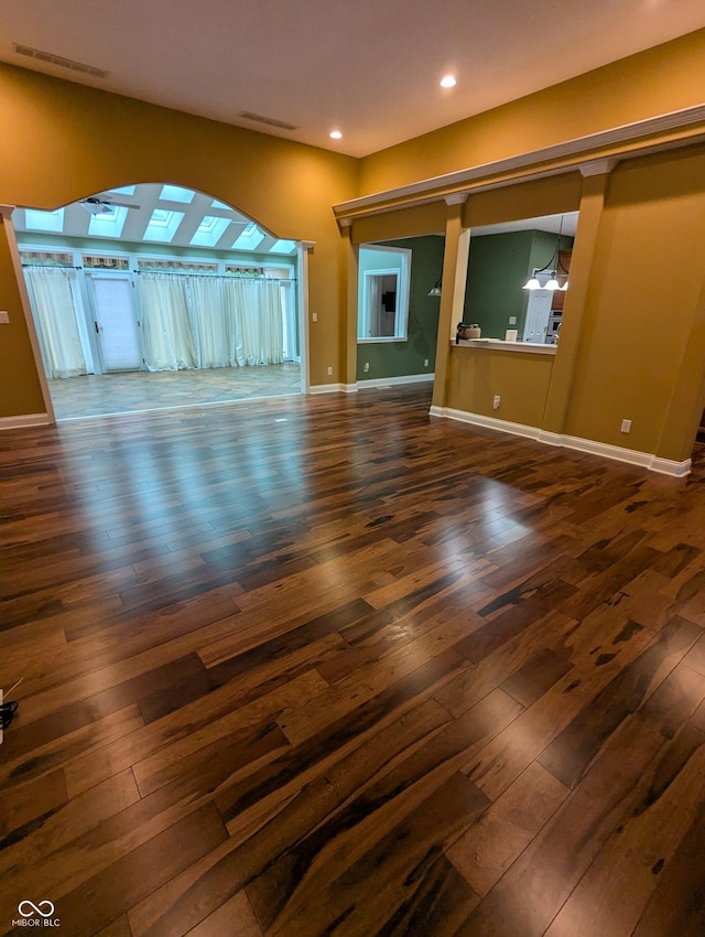 9640 Bramblewood Way, Carmel, IN 46032 - unfurnished living room with dark wood-type flooring, arched walkways, recessed lighting, and baseboards