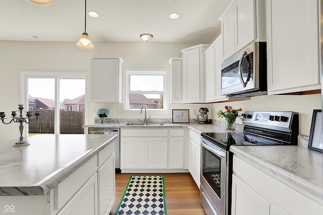 49 Manchester Dr, Trafalgar, IN 46181 - kitchen with stainless steel appliances, a sink, light wood-style floors, white cabinets, and recessed lighting