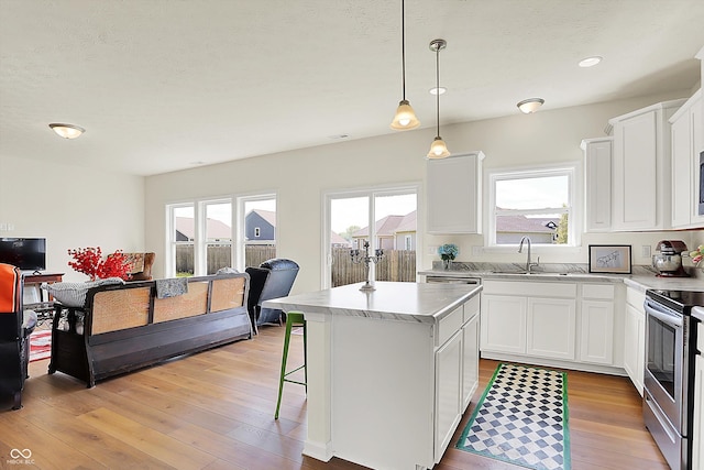 49 Manchester Dr, Trafalgar, IN 46181 - kitchen with a sink, electric stove, light wood-style floors, a kitchen island, and white cabinetry