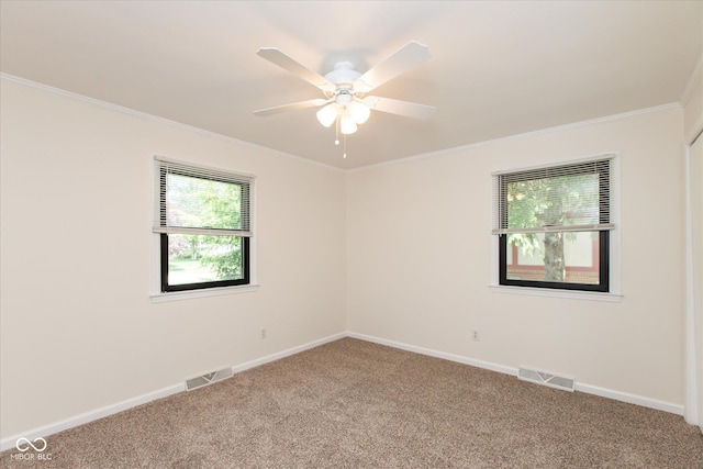 carpeted empty room featuring ornamental molding, ceiling fan, and baseboards