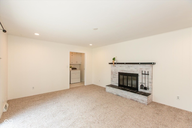 unfurnished living room featuring washer / clothes dryer, light colored carpet, a fireplace, and recessed lighting