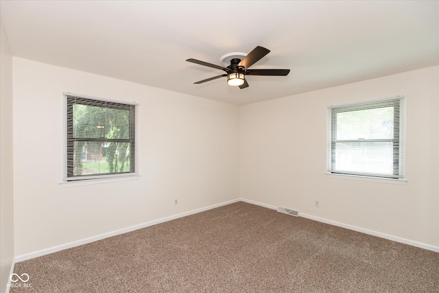 carpeted spare room featuring baseboards and ceiling fan