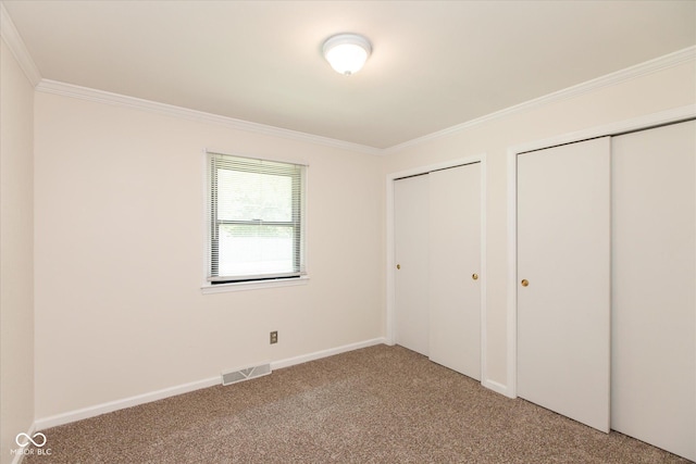 unfurnished bedroom with two closets, light carpet, ornamental molding, and baseboards