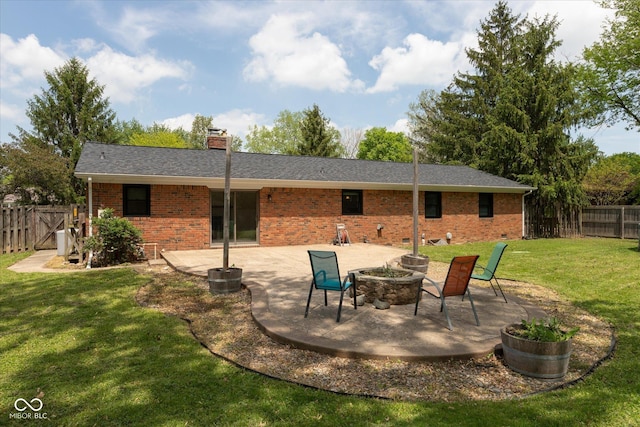 back of house featuring a patio area, brick siding, a chimney, and an outdoor fire pit