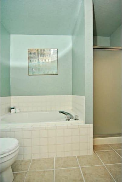 full bath with tile patterned floors, toilet, a garden tub, and a shower with shower door