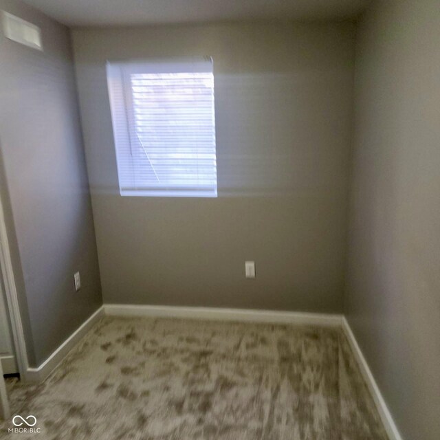 unfurnished room featuring carpet and baseboards