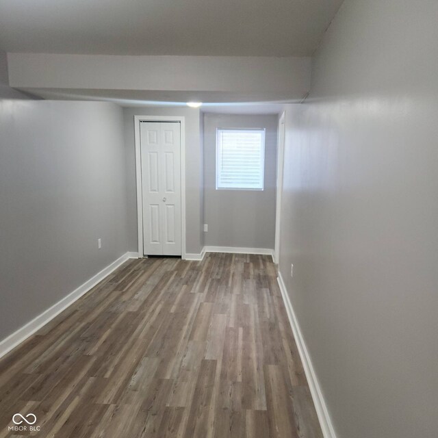 basement with dark wood-type flooring and baseboards