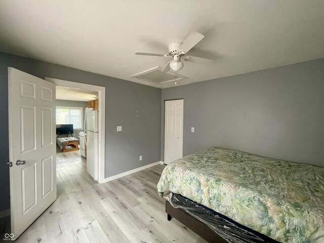 bedroom with light wood-type flooring, baseboards, a closet, and a ceiling fan