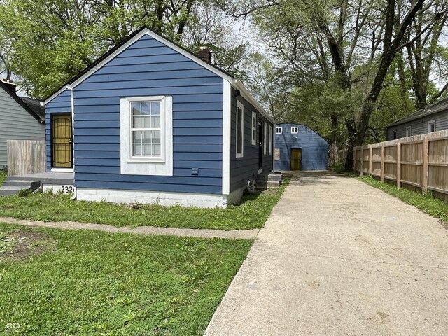 view of side of property with driveway, fence, and a chimney