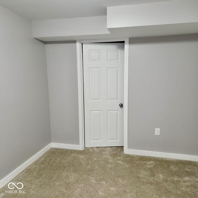 unfurnished bedroom with carpet flooring, baseboards, and a closet