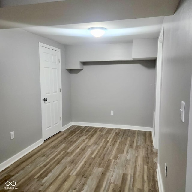 finished below grade area featuring wood finished floors and baseboards