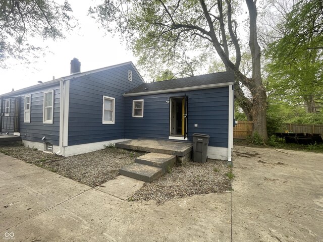 rear view of property with fence and a chimney