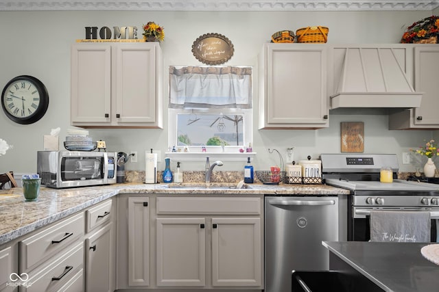 kitchen featuring stainless steel appliances, premium range hood, a sink, and light stone countertops