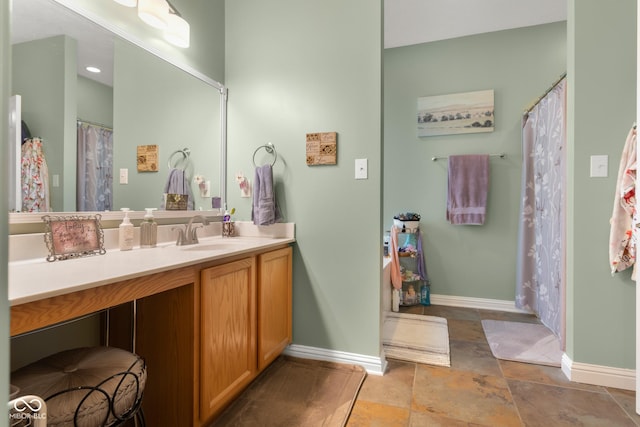 bathroom with baseboards, vanity, and stone finish floors