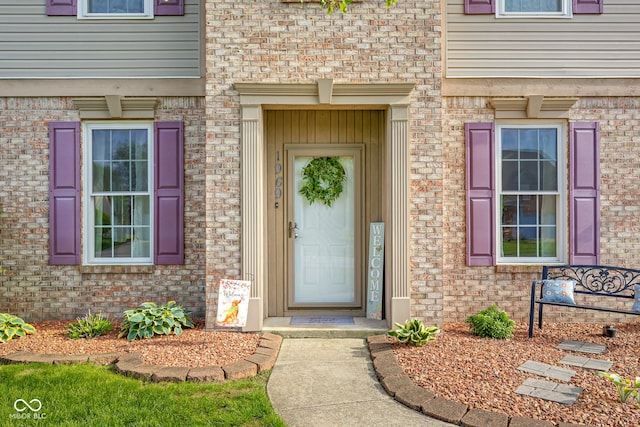 entrance to property featuring brick siding