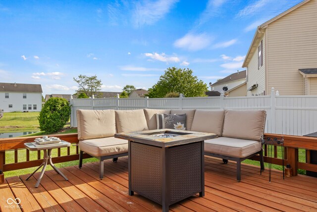 deck with an outdoor living space with a fire pit and a fenced backyard