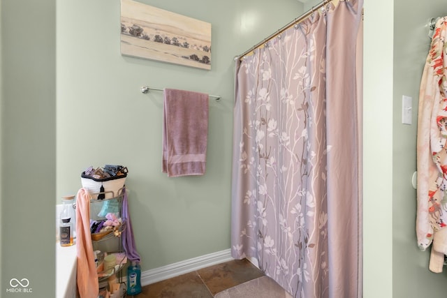 bathroom featuring baseboards and curtained shower