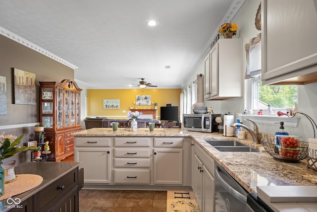 kitchen featuring stainless steel appliances, a peninsula, a ceiling fan, crown molding, and a sink