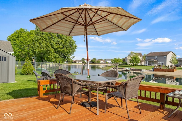 deck featuring a water view, a residential view, and outdoor dining space