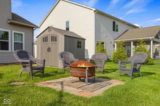 back of house featuring an outdoor fire pit, a shed, an outbuilding, and a lawn