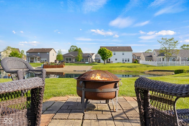 view of patio featuring an outdoor fire pit, a residential view, and a water view