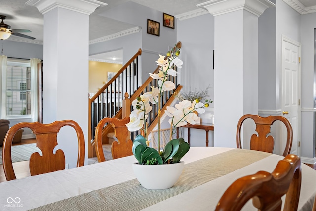 dining space featuring ornate columns, ceiling fan, and stairway