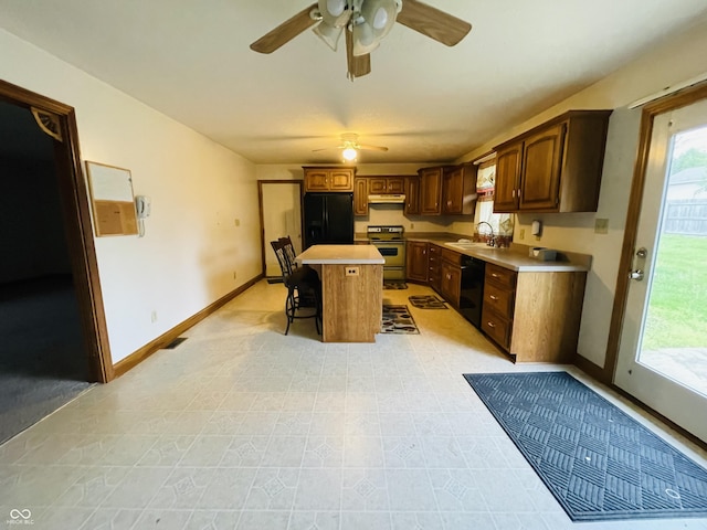 4706 W Old Trail Rd, Knightstown, IN 46148 - kitchen with black appliances, a sink, under cabinet range hood, ceiling fan, and a kitchen bar