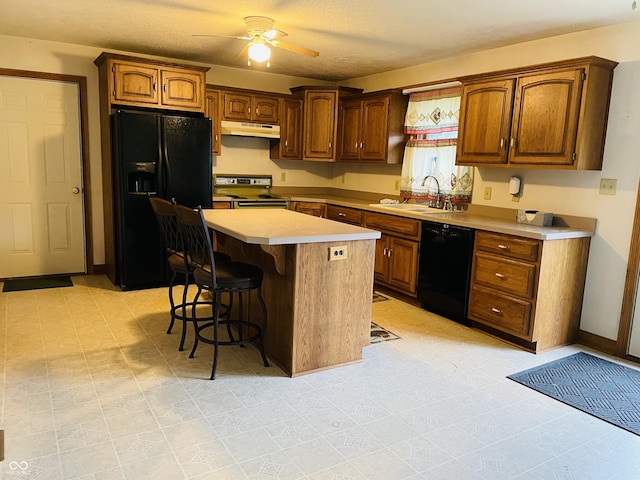 4706 W Old Trail Rd, Knightstown, IN 46148 - kitchen featuring black appliances, a sink, under cabinet range hood, a breakfast bar area, and light countertops