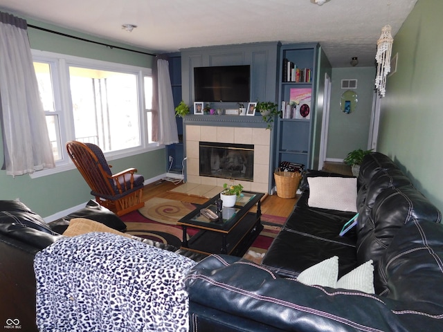 2867 S Oakland Dr, Shelbyville, IN 46176 - living room featuring wood finished floors, baseboards, and a tile fireplace