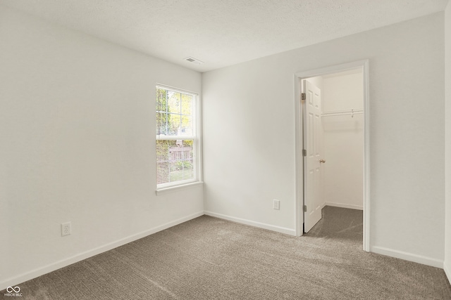 7156 Chemistry Ct, Indianapolis, IN 46239 - unfurnished bedroom featuring carpet floors, a spacious closet, baseboards, a closet, and a textured ceiling