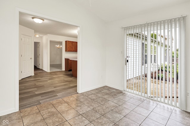 7156 Chemistry Ct, Indianapolis, IN 46239 - spare room featuring a chandelier, baseboards, and light tile patterned floors