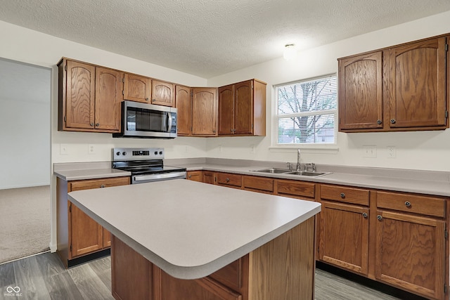 7156 Chemistry Ct, Indianapolis, IN 46239 - kitchen featuring appliances with stainless steel finishes, a sink, light wood-type flooring, light countertops, and a textured ceiling