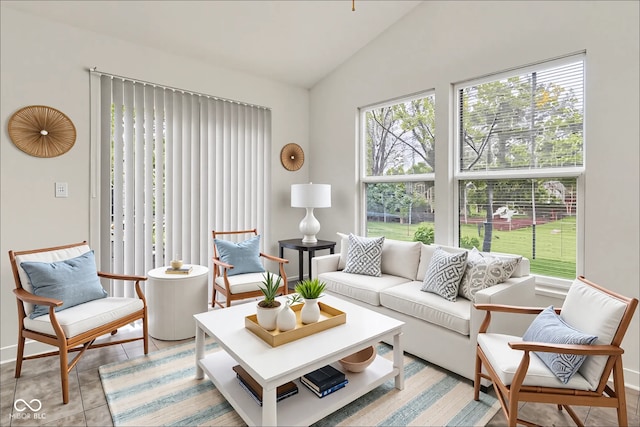 7156 Chemistry Ct, Indianapolis, IN 46239 - living area featuring vaulted ceiling, baseboards, and light tile patterned floors
