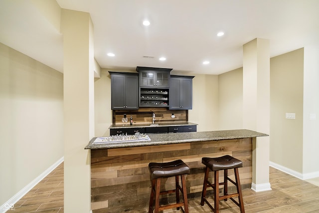 14003 Grannan Ln, Carmel, IN 46074 - indoor wet bar with light wood-style flooring, baseboards, decorative backsplash, and recessed lighting