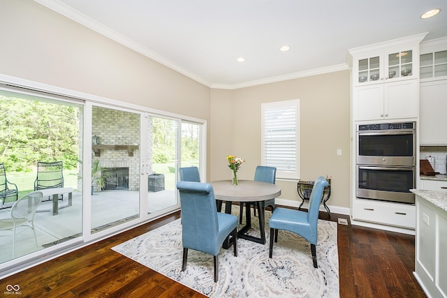14003 Grannan Ln, Carmel, IN 46074 - dining area featuring dark wood-type flooring, ornamental molding, recessed lighting, baseboards, and a brick fireplace