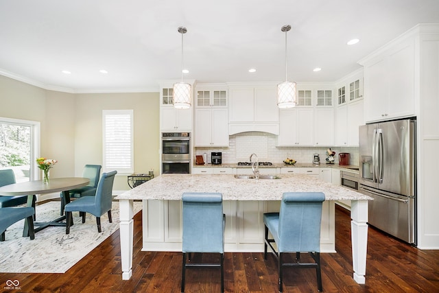 14003 Grannan Ln, Carmel, IN 46074 - kitchen with appliances with stainless steel finishes, dark wood-style flooring, glass insert cabinets, decorative backsplash, and a center island with sink