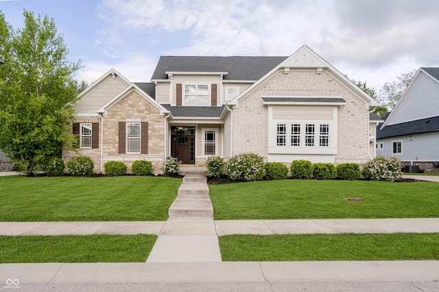 14003 Grannan Ln, Carmel, IN 46074 - craftsman-style home with a front yard, stone siding, and central air condition unit