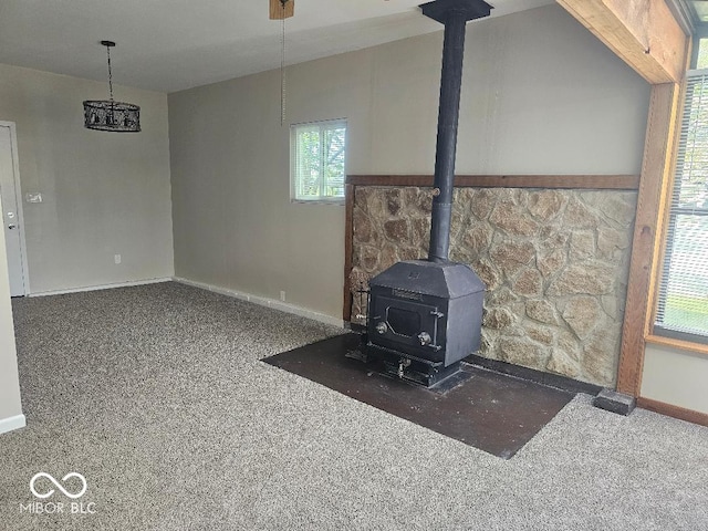 706 Alexander St, Greenwood, IN 46143 - unfurnished living room with a wood stove, carpet, and baseboards