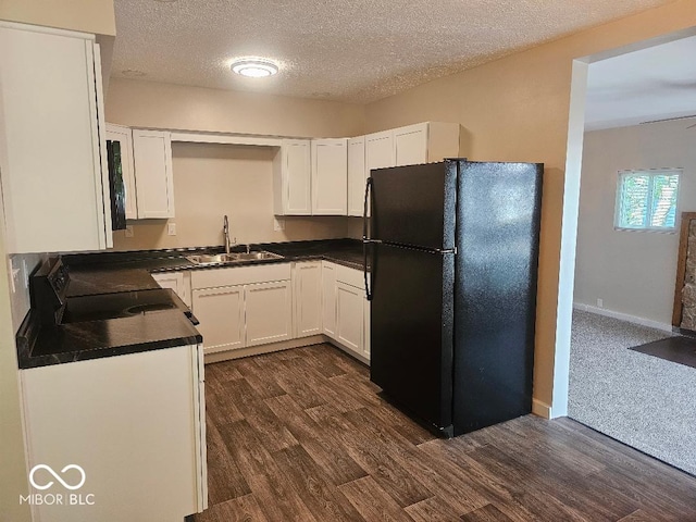 706 Alexander St, Greenwood, IN 46143 - kitchen with freestanding refrigerator, a sink, dark countertops, range, and dark wood-style flooring