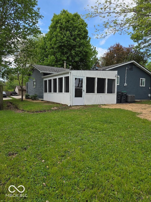 706 Alexander St, Greenwood, IN 46143 - rear view of house with a sunroom, a lawn, and cooling unit